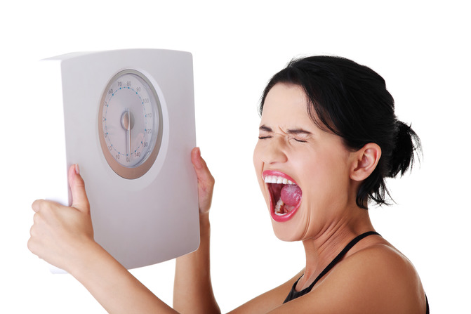 frustrated woman holding a scale