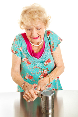 Senior woman with arthritis struggles to open a can.