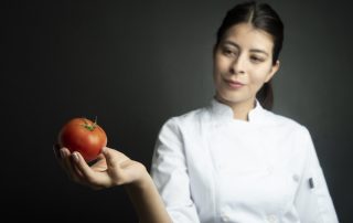 Chef looking at tomato/Adobe stock