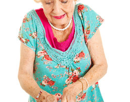 Senior woman with arthritis struggles to open a can.