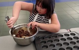 Student making quinoa pizza bites in school