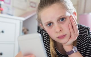 Young girl looking at phone/cyberbullying