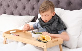 Sick boy eating chicken soup