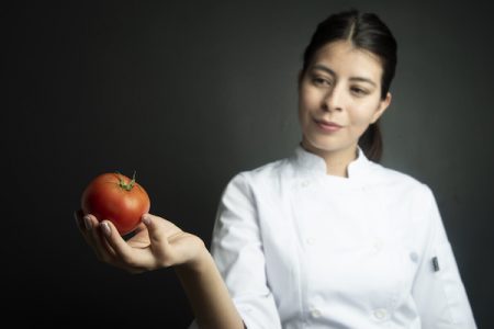 Chef looking at tomato/Adobe stock