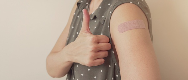 Person with thumb up after getting COVID vaccine